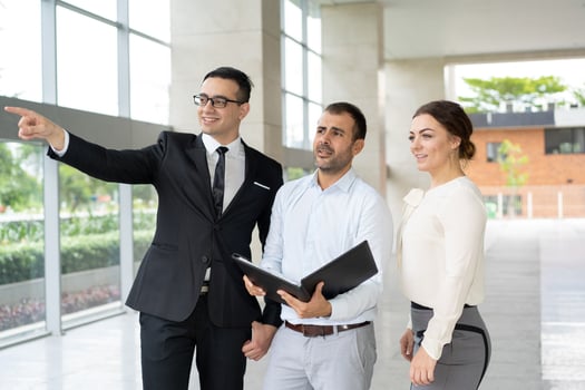 smiling-manager-showing-real-estate-object-investors